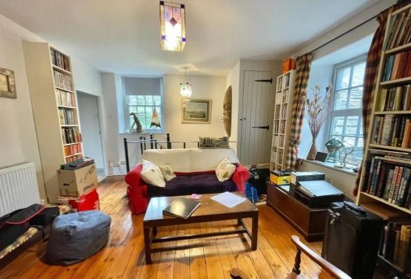 The first-floor sitting room has stripped wood flooring and is accessed from the spiral staircase. One door leads to bedroom two and another door accesses barn one.