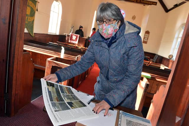 Fernilee Chapel is celebrating its Sesquicentennial (150 years). Looking for Time Capsule that was buried into the original stone work 150 years ago. Donna Hodgson looking at book with a description where the time capsule could be placed.
