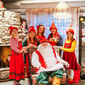 Santa Claus and his helpers ready to receive letters from around the world