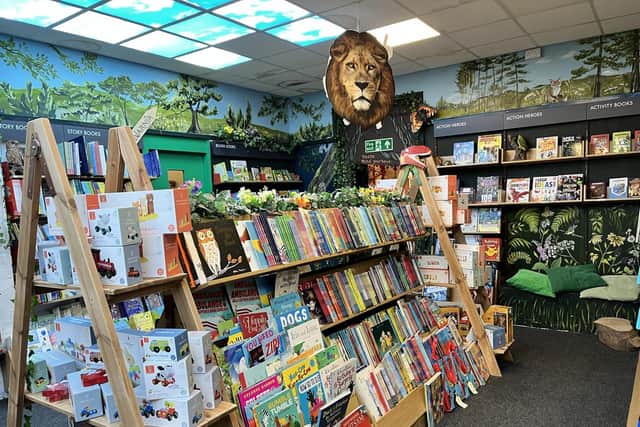 The children's area boasts an impressive collection of books and charming decor, with young readers tucked into every nook, engrossed in their beloved stories.