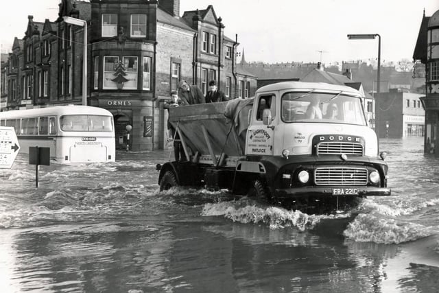 A truck is used to ferry people across Crown Square after flooding in Matlock in December 1965.