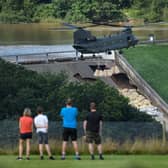 Residents look on as an RAF Chinook helicopter drops sandbags onto the dam wall at Toddbrook reservoir. Photo by Leon Neal/Getty Images