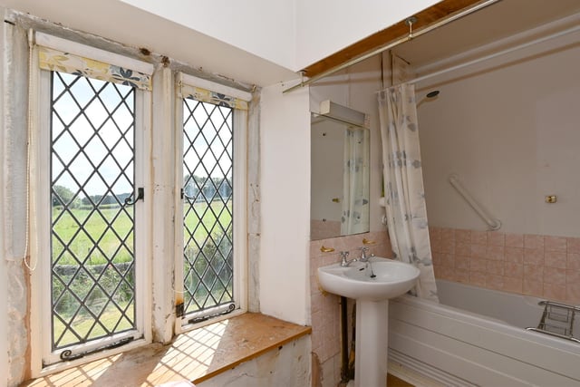 This bathroom with leaded windows looks out over the gardens and fields beyond.