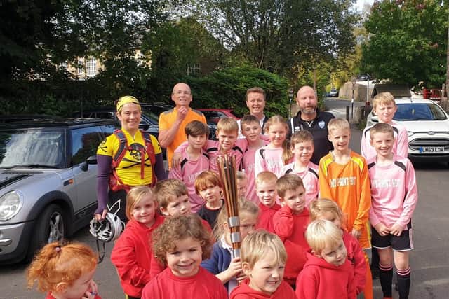 Kettleshulme pupils surround the baton relay team.