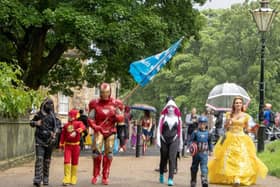 Buxton Ironman Andy Baker leads the superhuman posse while holding an NHS flag - photo by Matthew Day