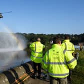 A Chinook helicopter creates a rainbow in the spray as it prepares to drop sandbags onto the dam wall at Toddbrook reservoir. (Photo by Leon Neal/Getty Images)