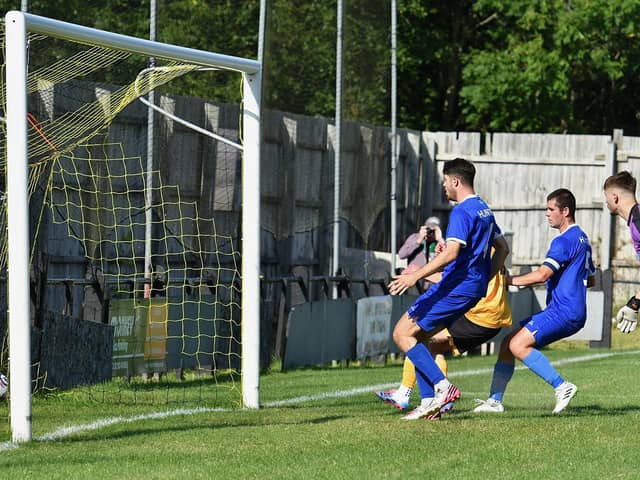 Tyler Barnes (hidden) scores New Mills' second goal. Photo: John Fryer.