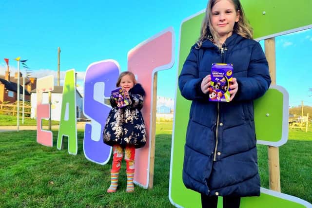 Children at Bluebells Farm Park standing infront of Easter sign