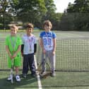 Three youngsters get ready to play at Buxton Tennis Club.