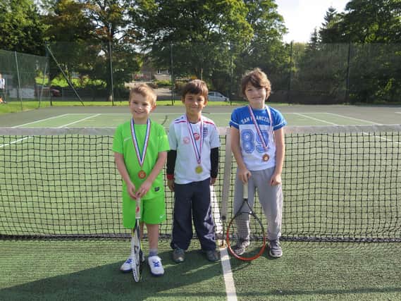Three youngsters get ready to play at Buxton Tennis Club.