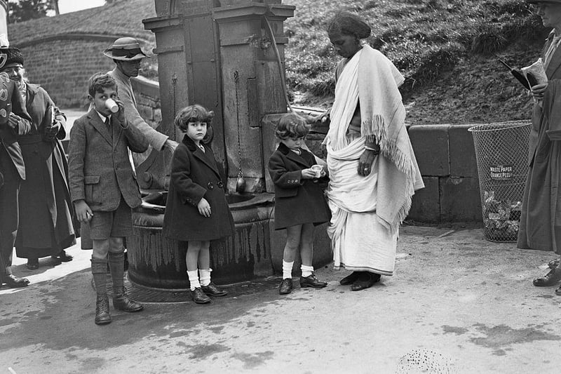Children with their Indian nanny at St Ann's Well in Buxton in August 1922. The water pump provides water from a geothermal spring.