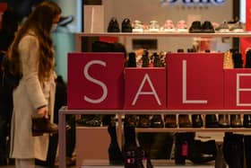 A customer shops for discounted shoes. (Photo by Artur Widak/NurPhoto via Getty Images)