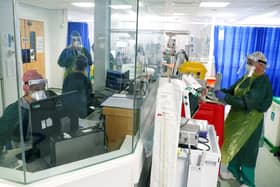 Medical staff wearing full PPE (personal protective equipment), including a face mask, long aprons, and gloves as a precautionary measure against COVID-19, work on an Intensive Care Unit (ICU) ward treating patients with COVID-19, at Frimley Park Hospital in Frimley, southwest England on May 22, 2020. - Britain's number of deaths "involving" the coronavirus has risen to 46,000, substantially higher than the 36,914 fatalities officially reported so far, according to a statistical update released Tuesday. (Photo by Steve Parsons / POOL / AFP) (Photo by STEVE PARSONS/POOL/AFP via Getty Images)