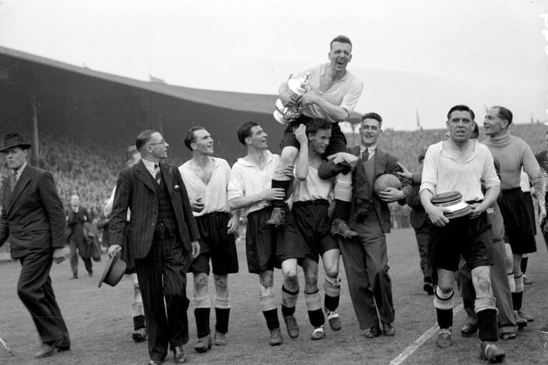 The Derby County team make a lap of honour around Wembley Stadium, carrying their captain Jack Nicholas and the FA Cup trophy, after their 4-1 victory over Charlton Athletic in the FA Cup final on 19th April 1946.