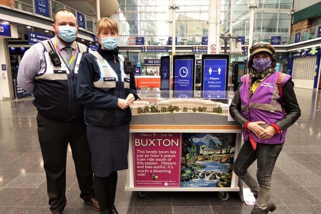 The Kenneth Steel inspired “bee-line to Buxton” travel poster and The Crescent hotel and spa buildings model on the main concourse at Manchester Piccadilly Station flanked by (from left) Matthew Jump, Piccadilly’s Deputy Station Manager, Margaret Edge, Piccadilly’s Station Control Manager and Sue Mellor, Secretary, Friends of Buxton Station.