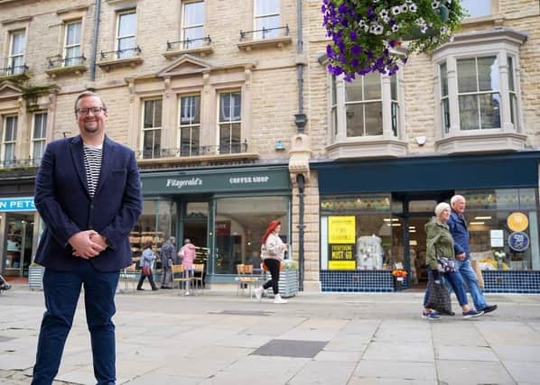Councillor Damien Greenhalgh, Deputy Leader and Executive Councillor for Regeneration, Tourism and Leisure outside the newly renovated shops in Buxton. Photo High Peak Borough Council