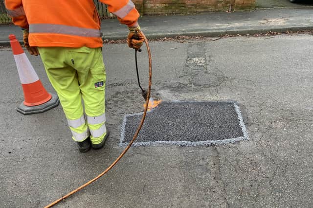 Pictured Is A Derbyshire County Council Worker Sealing A Repaired Pothole On One Of The County\'S Roads