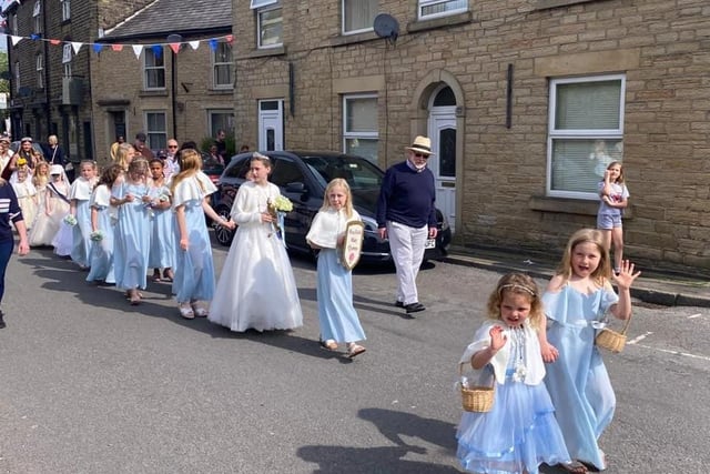 The walking retinue giving a cheeky wave. Pic Hayfield May Queen
