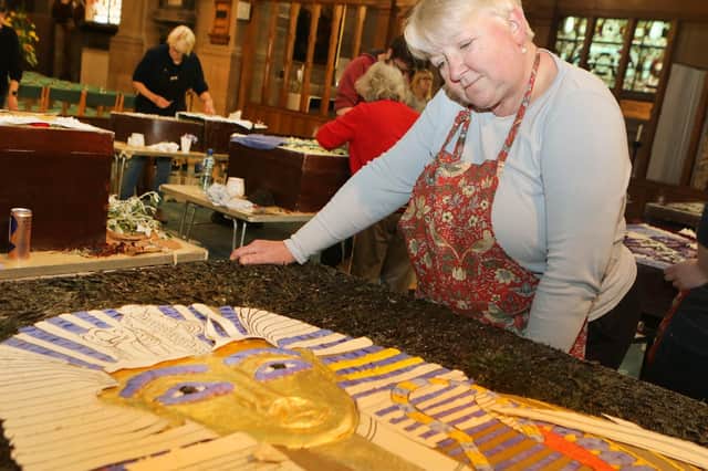 The main panel of the Market Place Well features the centenary of the discovery of Tutankhmun's Tomb, Christine Gould admires the real gold leaf used on the face mask