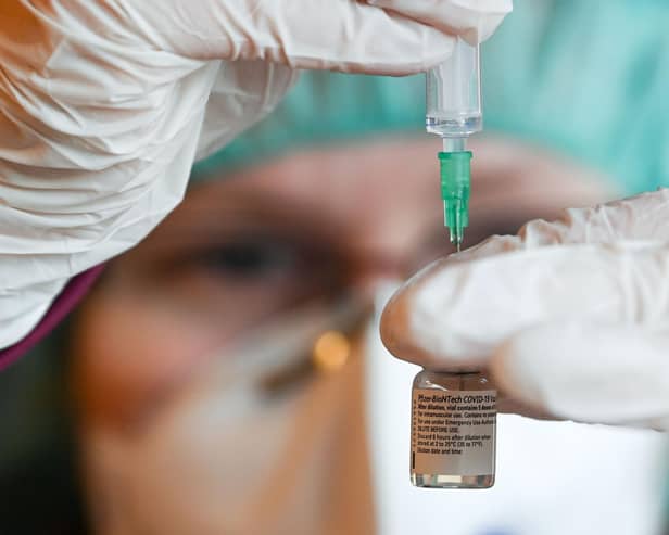 A pharmacist prepares a dose of the Pfizer-BioNTech COVID-19 vaccine. (Photo by HENDRIK SCHMIDT/POOL/AFP via Getty Images)