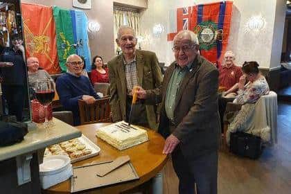 Longstanding club members Reg and Arthur cut the anniversary cake.