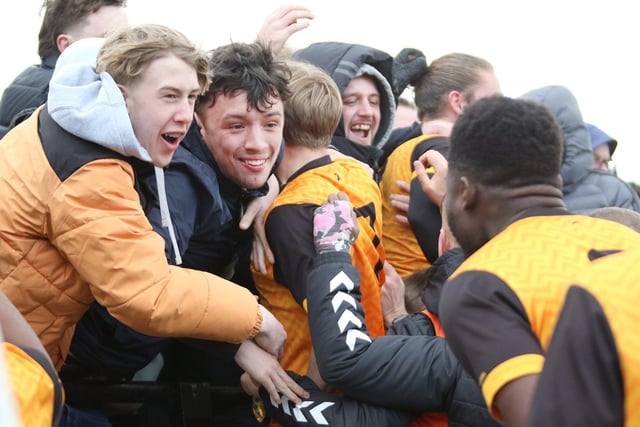 New Mills' fans celebrate with the players after the winning goal.