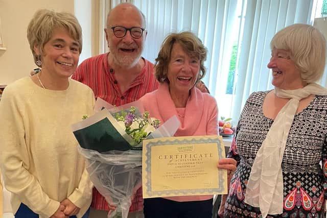 Christine, third from left, receives a certificate to commemorate her 25th anniversary as a Samaritan from fellow volunteers Deborah, Julian and Maggie.