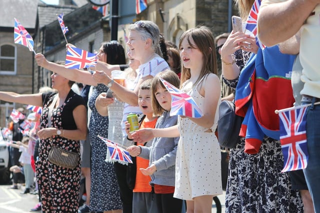 Crowds waving flags during the Whaley Bridge Platinum Jubilee Parade