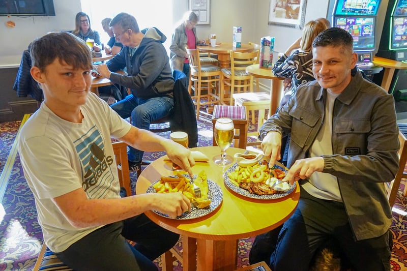 Two friends tucking into battered cod and chips and a large mixed grill. Photo Brian Eyre