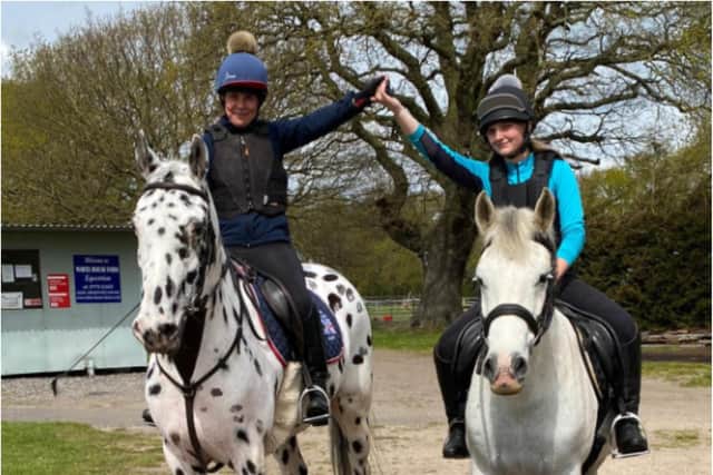 Mother and daughter, Anita Marsh and Alyssia riding together to train their young horse.