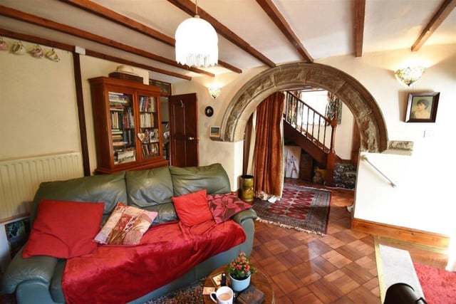 A glimpse of the inner hallway through the stone arch which is a focal point of the living room.