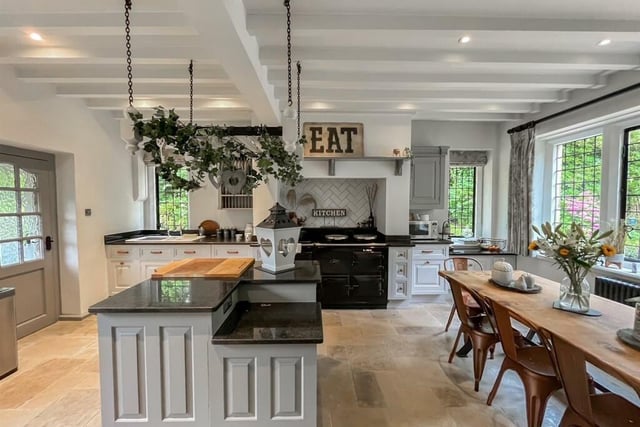 The dining kitchen is fitted with base storage units and a central island, accommodates a range cooker in the chimney alcove and has room for a large table overlooking the garden.