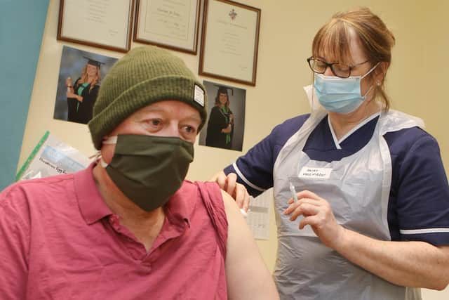 Vaccinator Helen Wren administers a dose of the Oxford Astra Zeneca vaccine to Simon Glinn