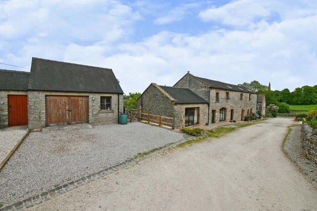 The property has a separate garage/workshop with three levels of overhead storage inside. There is parking space for three cars in front of it
