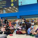 Tourists wait in the airport's departure hall as evacuations are underway due to wildfires, on the Greek island of Rhodes on July 23, 2023.