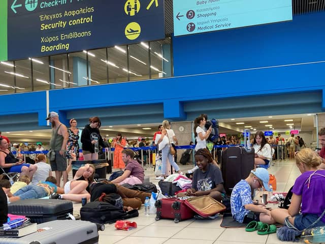 Tourists wait in the airport's departure hall as evacuations are underway due to wildfires, on the Greek island of Rhodes on July 23, 2023.