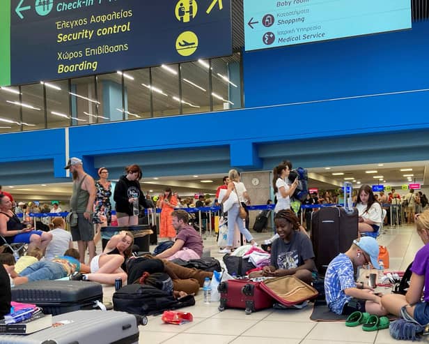 Tourists wait in the airport's departure hall as evacuations are underway due to wildfires, on the Greek island of Rhodes on July 23, 2023.