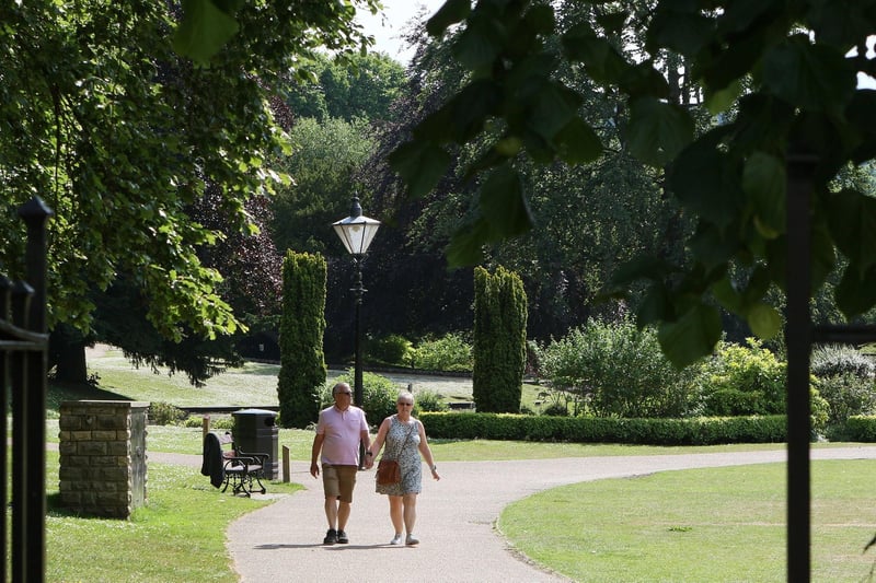Two walkers stroll hand in hand through the sunshine in Pavilion Gardens. Pic Jason Chadwick