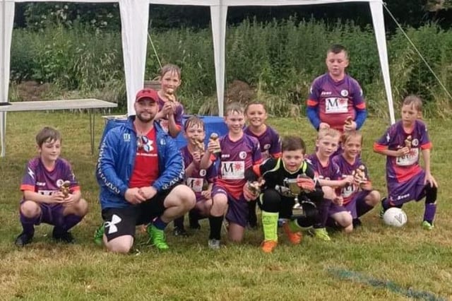 The successful Buxton Broncos side with their trophy.
