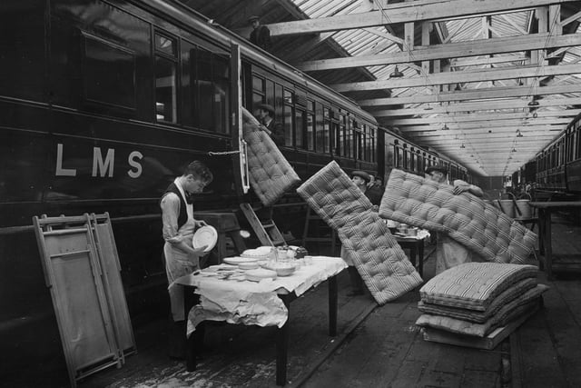 23rd February 1937:  Workmen carrying bedding into a caravan at the London Midland and Scottish Railway works in Derby, in readiness for the early season rush.  (Photo by Hudson/Topical Press Agency/Getty Images)
