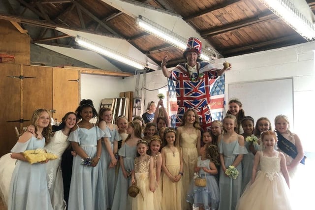 Stilt walker Mad Dominic with some of the royal retinue. Pic Hayfield May Queen