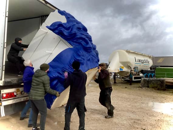 Giant blue head is carefully offloaded from its container.