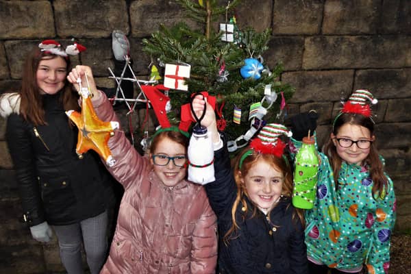Four pupils from Buxton Junior School fastening some of the recycled decorations to the community Christmas tree at Buxton station. The girls are sisters, from left to right: Erin Taylor, Ellie Preece-Gregory, Lilly Preece-Gregory and Evie Taylor.
