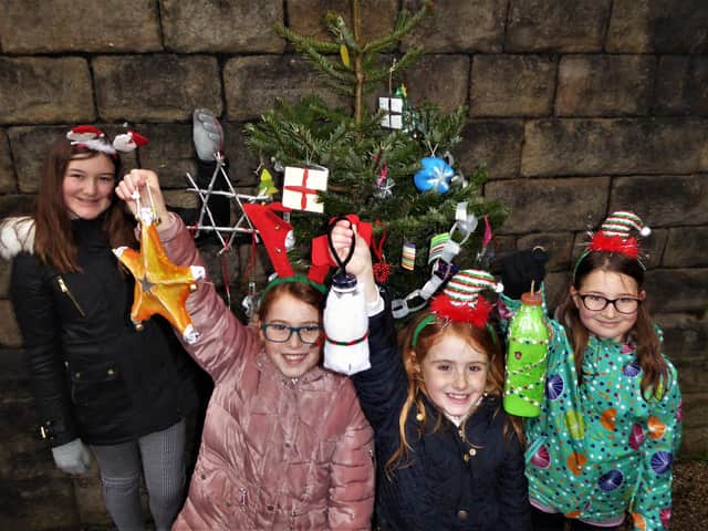 Four pupils from Buxton Junior School fastening some of the recycled decorations to the community Christmas tree at Buxton station. The girls are sisters, from left to right: Erin Taylor, Ellie Preece-Gregory, Lilly Preece-Gregory and Evie Taylor.