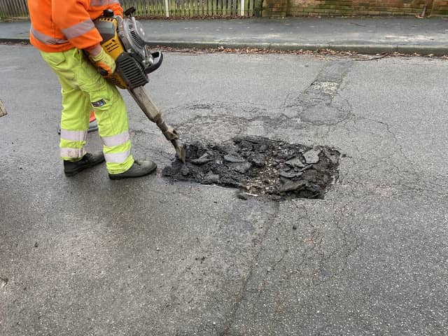 Derbyshire County Council worker repairing one of the many potholes on the county's roads