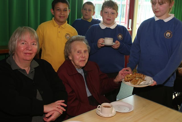Chapel Primary, Easter coffee morning for pensioners, guests Maureen Hill and Vera Williams are served hot cross buns by pupils