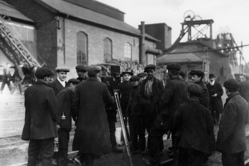 Derbyshire Miners are pictured surrounding a cinematographer at work in 1912.