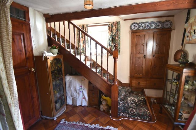 Wooden staircase, ceiling beams and door are eye-catching features of the inner hallway.