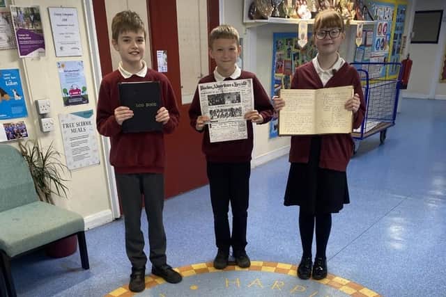 The school's head boy, deputy head boy and deputy head girl show off some of their archive discoveries.