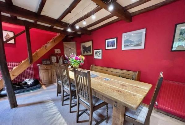Plenty of room to enjoy a meal in this spacious room which has a a cast iron stove, eye-catching ceiling beams and an open staircase.